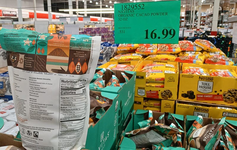 Costco warehouse shelf of Navitas Organic Cacao Powder 32 oz bags with a $16.99 price sign