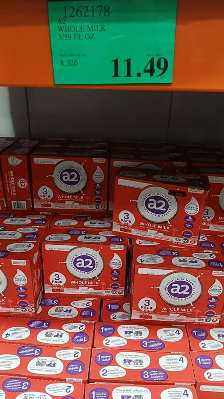 Costco display of a2 whole milk three-packs with an $11.49 price sign