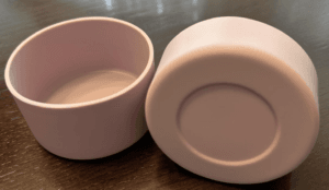 Two pink silicone tumbler boots, one upright and one turned to show its recessed base