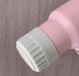 White silicone tumbler boot personalized with the name ‘Amanda,’ fitted on a pink tumbler