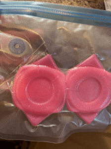 Two pink silicone tumbler boots in a clear resealable bag