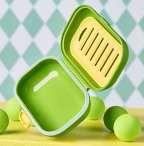 Green silicone travel soap case with a drainage-and-ventilation design shown in an exploded view