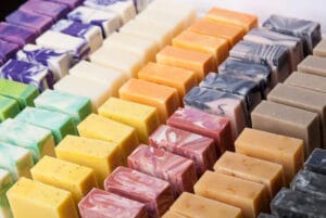 Rows of colorful handmade cold-process soap bars in many natural colors